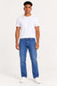 Jeans | Calça Baggy Jeans Masculina Barra Normal Revanche na cor jeans, vestida em modelo com camiseta branca e tênis branco