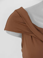 Detalhe frontal do decote e drapeado superior da blusa feminina