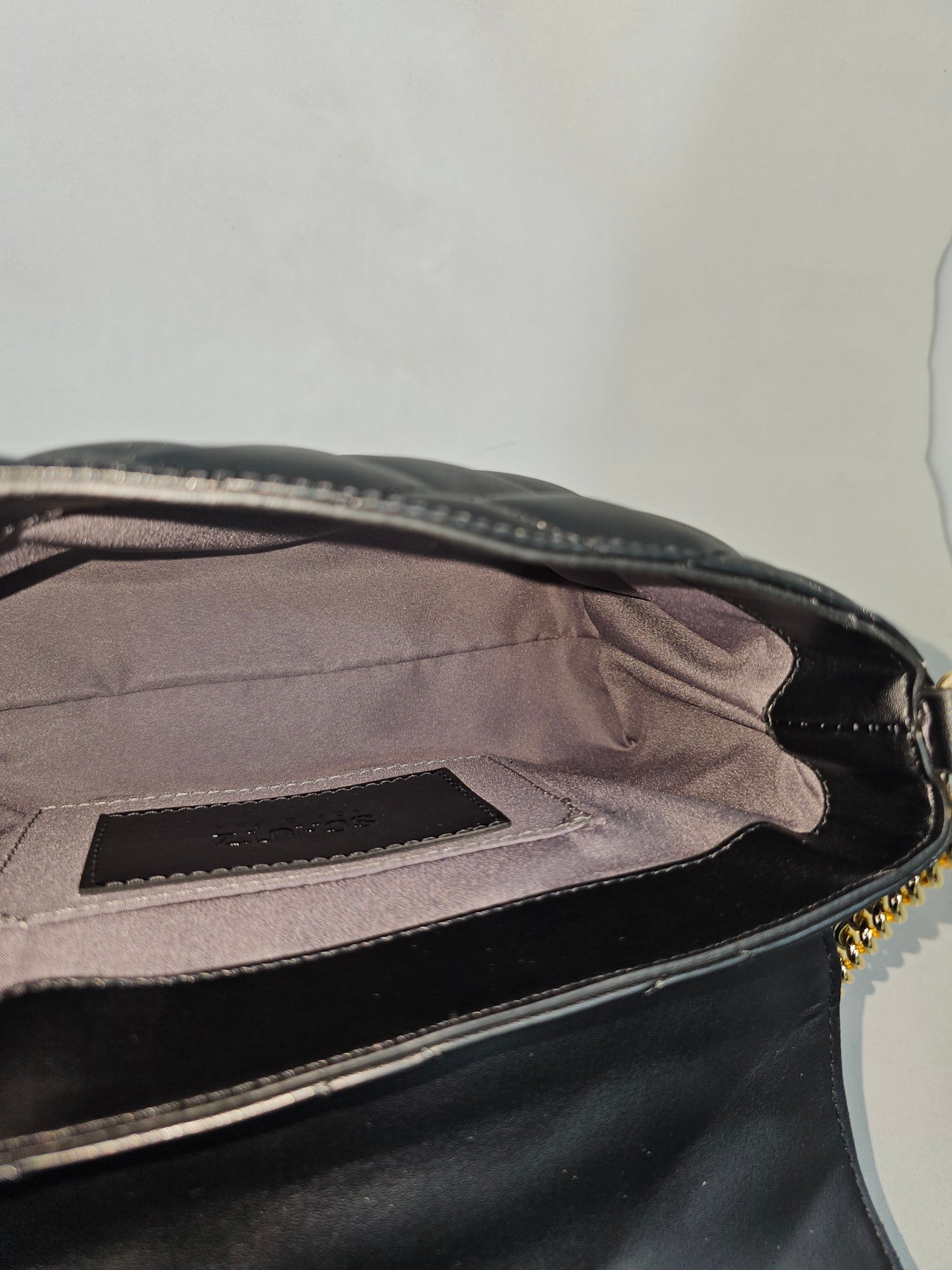 Detalhe matelassê e alça bolsa crossbody Schutz