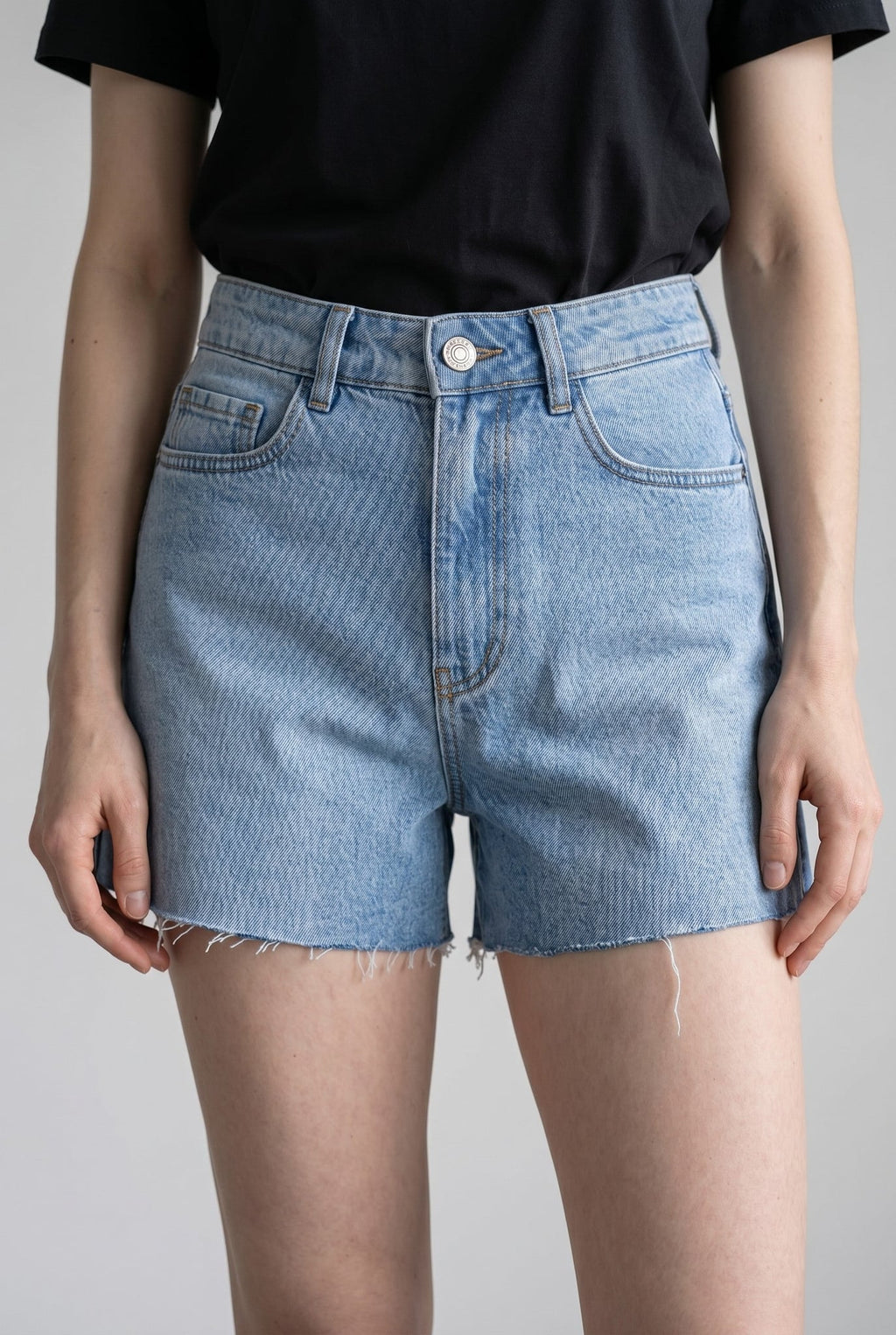 Shorts Skenn Denim jeans azul claro de cintura alta, vista da frente com barra desfiada