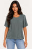 Verde | Blusa Skenn Basic Gloss verde, manga curta e decote redondo, vestida na modelo com jeans