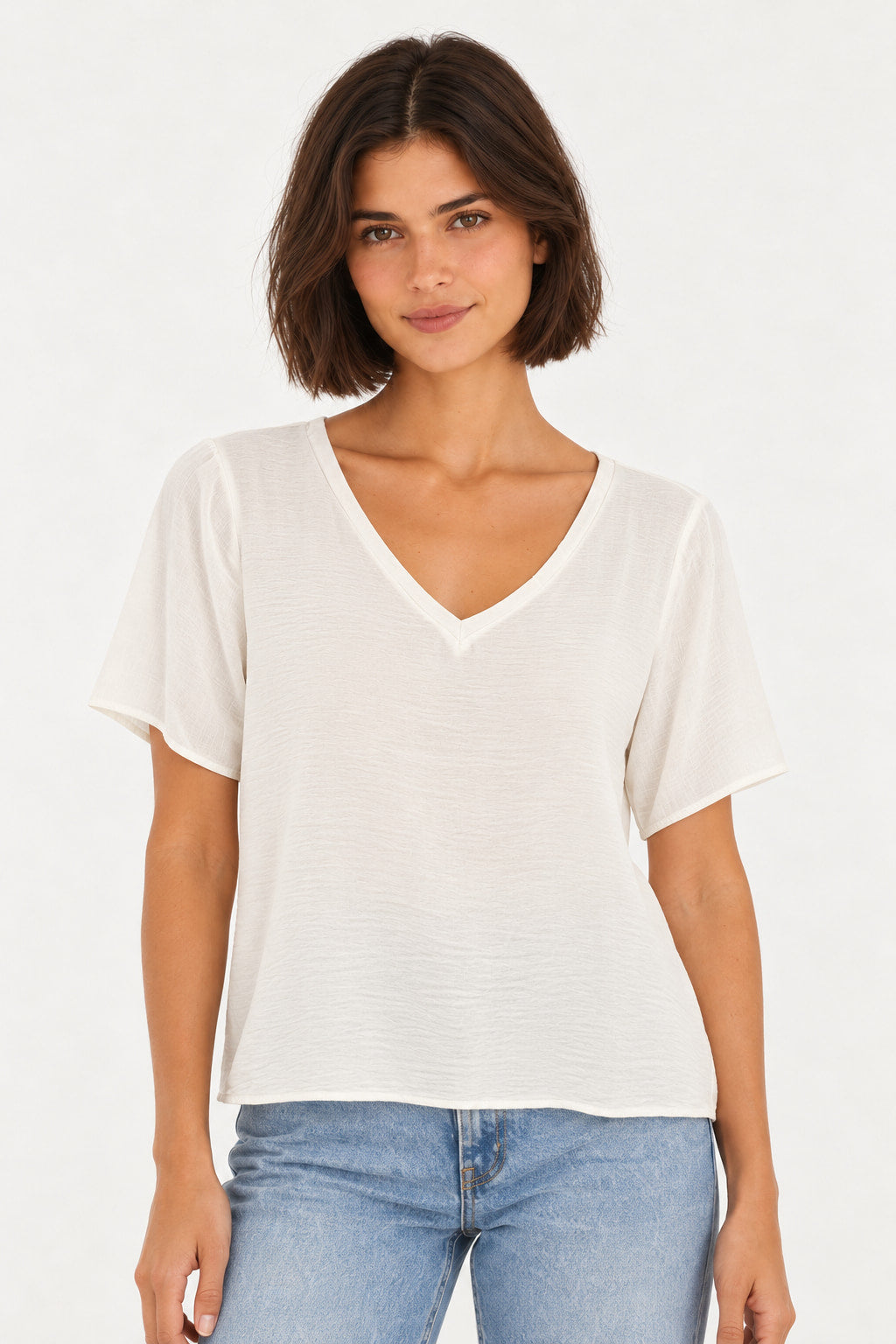 Branco | Blusa Básica Gola V Manga Curta Aishty em branco, vestida na modelo com jeans azul, vista frontal