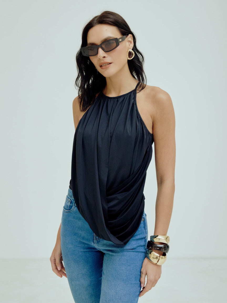 Blusa Begônia Fluidez Skenn preta de alças finas e caimento drapeado, combinada com jeans e óculos escuros
