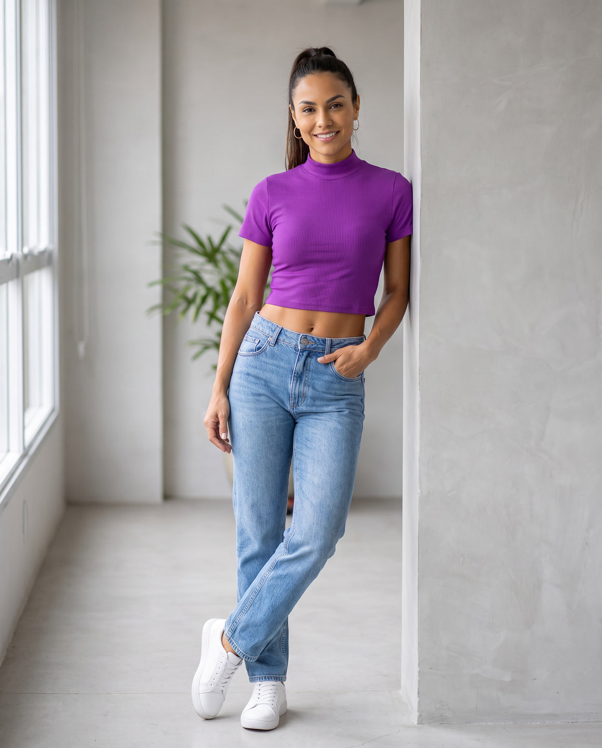 Blusa Groovy Cropped Gola Canelada roxa de gola alta, modelo sorridente com calça jeans clara e tênis branco