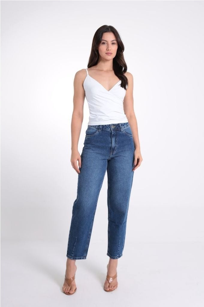 Blusa alcinha com transpasse Revanche branca combinada com calça jeans reta de cintura alta, look de corpo inteiro