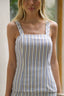Blusa Skenn Listrada Resort em listras verdes, marrons e off-white, com alças largas e decote reto, vestida na modelo