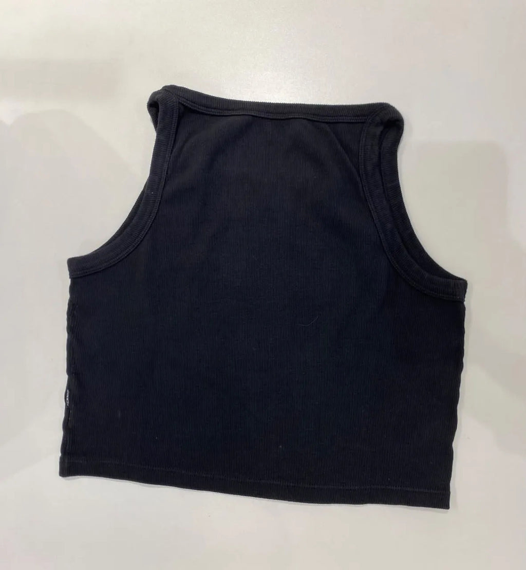 Blusa regata canelada Lerrux preta vista de costas, com recorte de gola e cava arredondados, estendida sobre superfície clara