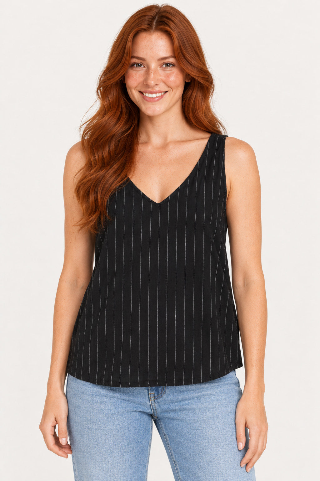 Preto | Blusa regata CS de linho listrado preto com listras verticais claras, decote V, vestida com jeans