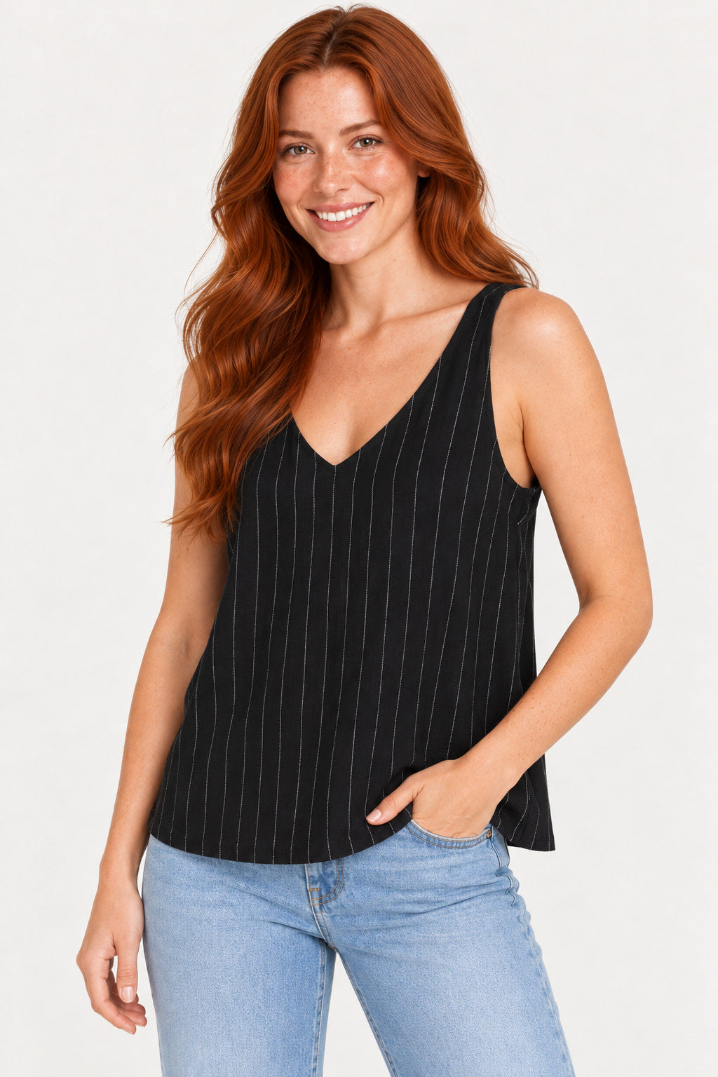 Preto | Blusa regata CS preta de linho listrado, caimento solto na modelo com uma mão no bolso do jeans