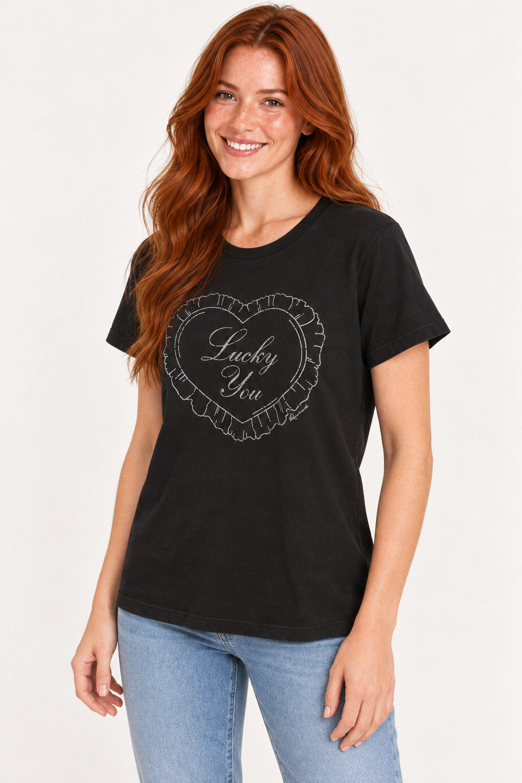 Preto | Blusa T-Shirt Estampada Revanche preta com estampa de coração Lucky You, vista de frente com a modelo de perfil leve