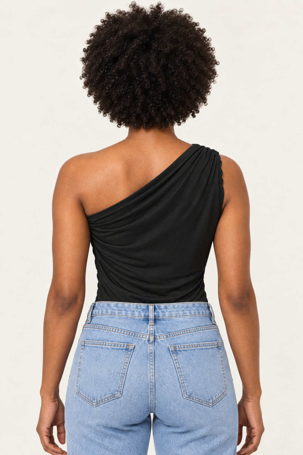 Preto | Body um ombro só CS preto de poliamida visto de costas, com o drapeado do ombro e calça jeans azul claro