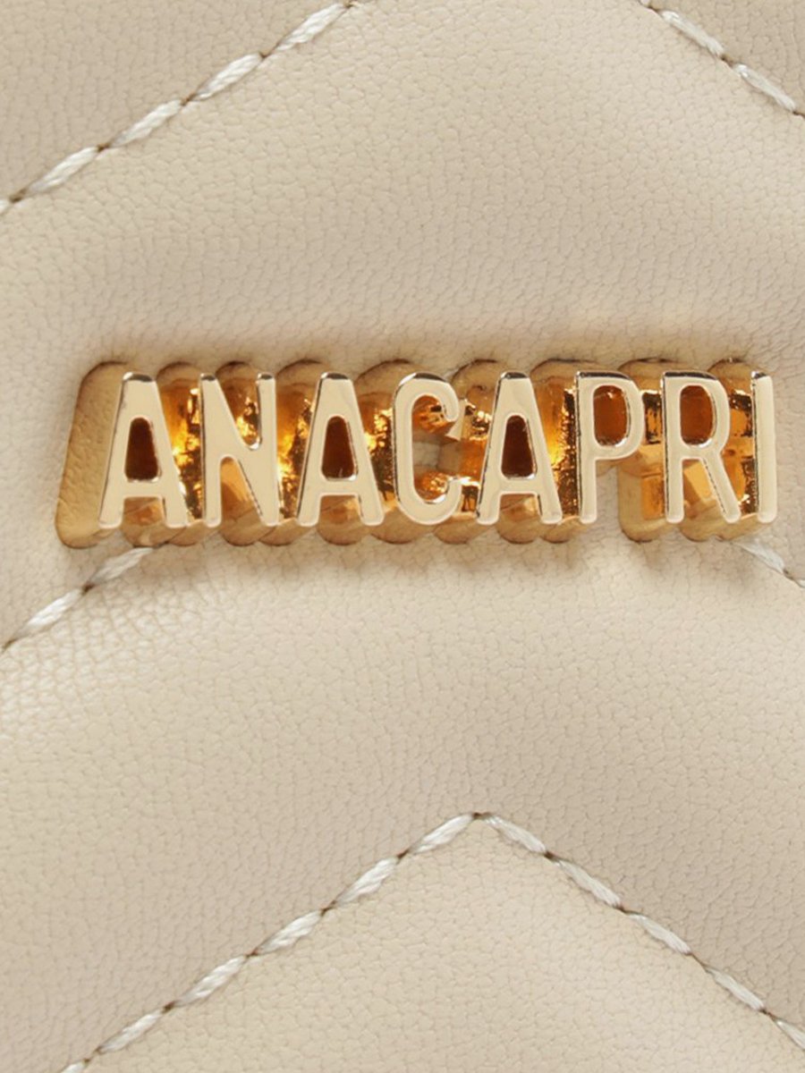 Bolsa tiracolo Anacapri média matelassê zig zag bege, detalhe do logo dourado sobre o matelassê