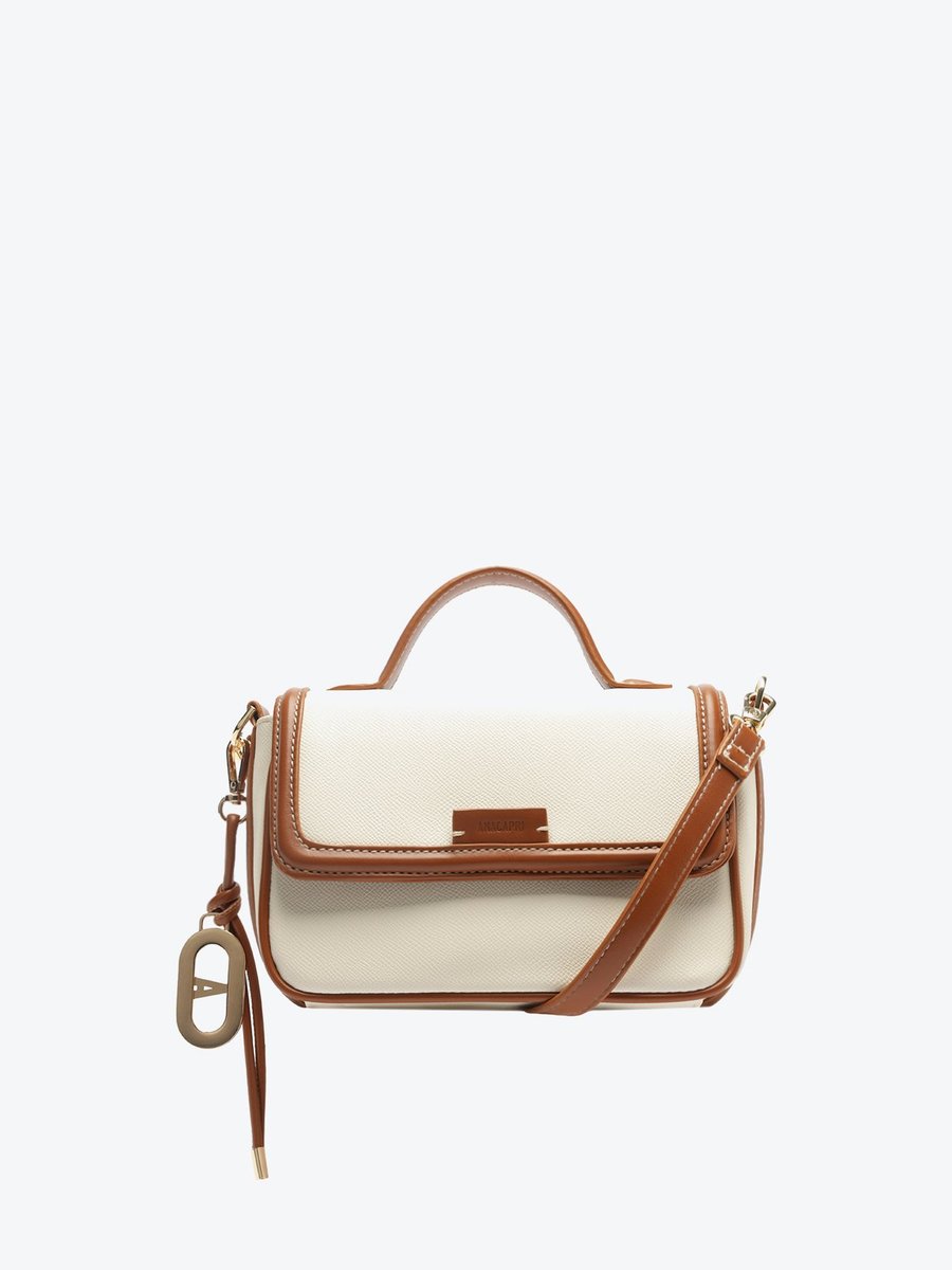 Bolsa tiracolo Anacapri Maleta Charm branca com aba caramelo e alça de mão, vista frontal de perto