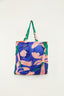 Bolsa Farm Me Leva Lisos Farm Etc em tecido estampado azul e rosa com alças verdes e chaveiro em forma de folha