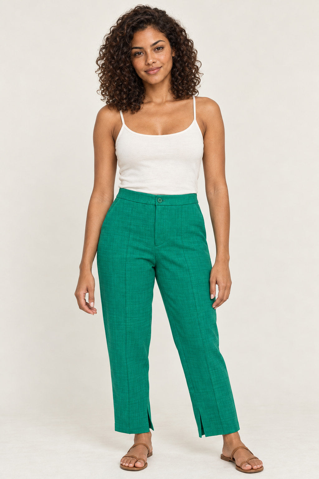 Verde | Calça Alfaiataria Chique Skenn verde, cintura alta com botão, vestida na modelo com regata branca e sandálias Imagem principal do produto