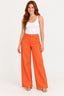Laranja | Calça Alfaiataria Wide Revanche laranja, vestida em modelo de cabelo ruivo com regata branca e sandália nude