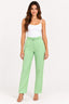 Verde | Calça Skenn alfaiataria com cinto verde claro, vestida em modelo com regata branca, vista de frente