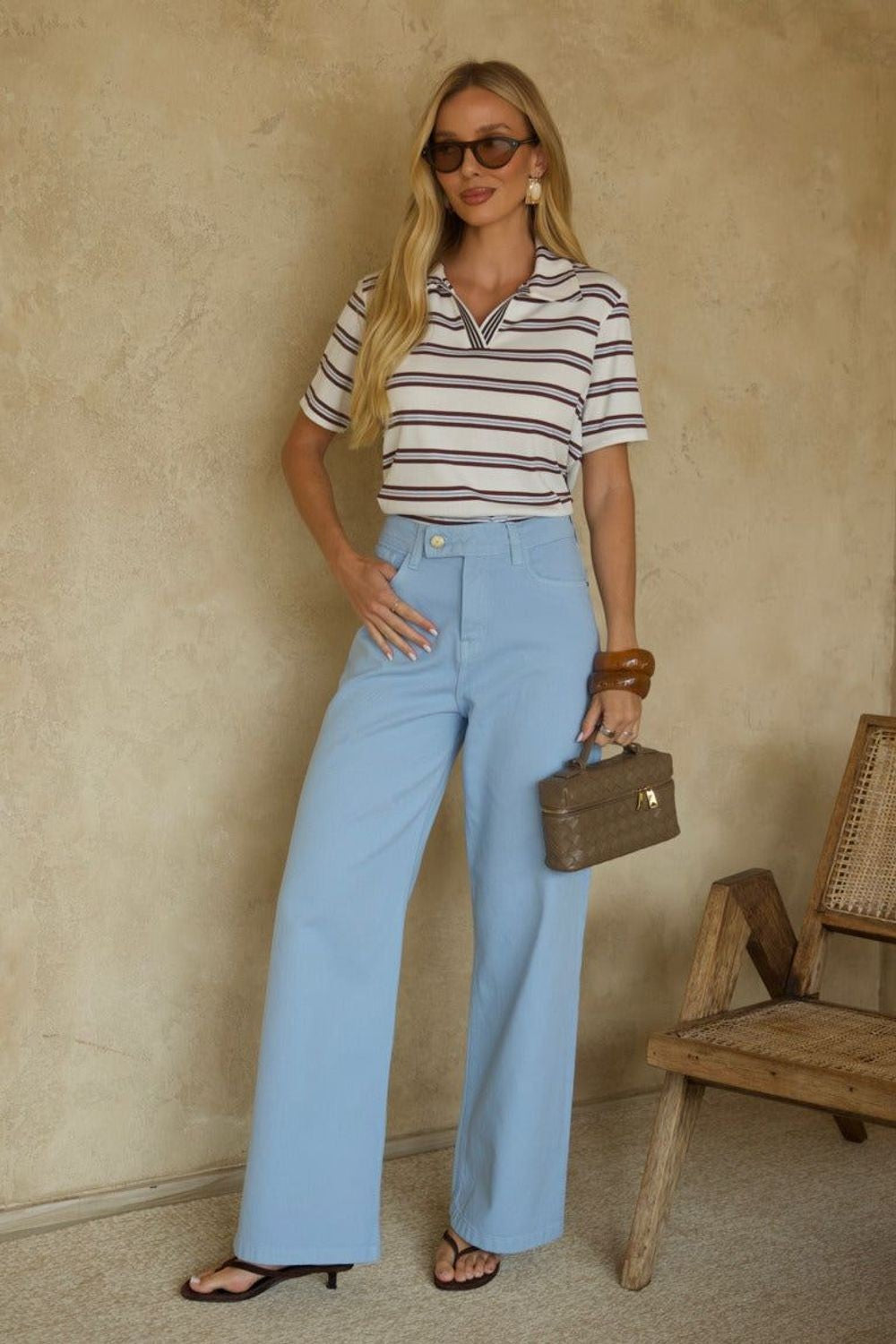Calça jeans azul Skenn Denin de cintura alta e perna reta, usada com camiseta listrada e acessórios