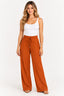 Caramelo | Calça feminina pantalona Clamarroca caramelo com cintura elástica e cordão, vestida em modelo com regata branca