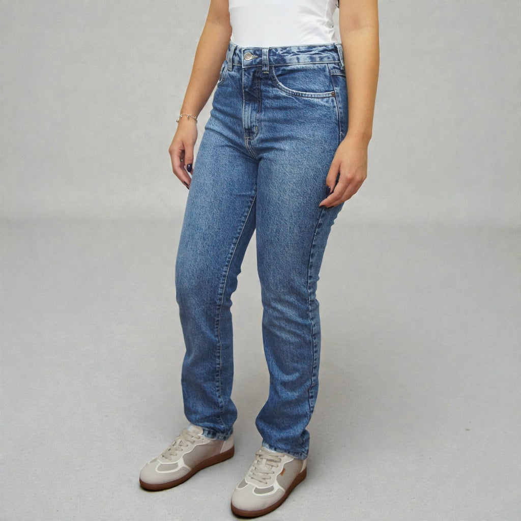 Calça jeans slim Belgium Lerrux em azul médio, vista lateral de corpo inteiro com a modelo