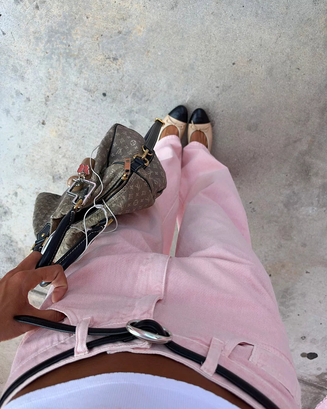 Calça Alcance New Baggy Botanic rosa vista de cima com sapatilhas bicolores e detalhe do cinto preto