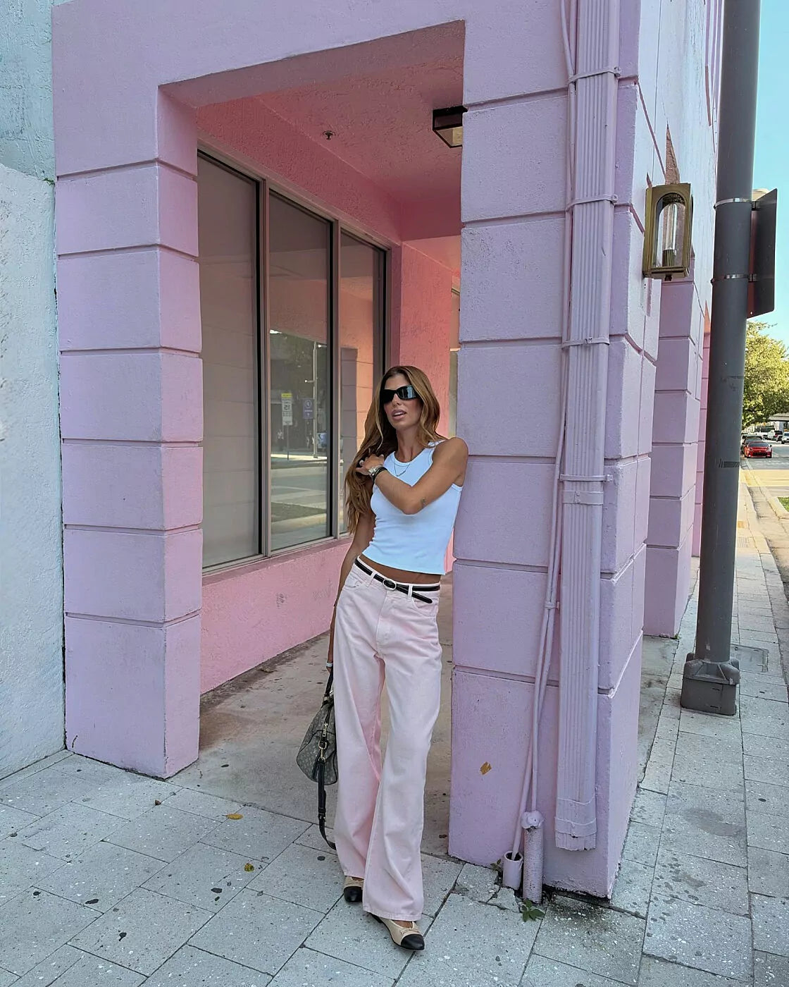 Calça Alcance New Baggy Botanic rosa de perna larga em look completo com regata branca em fachada rosa