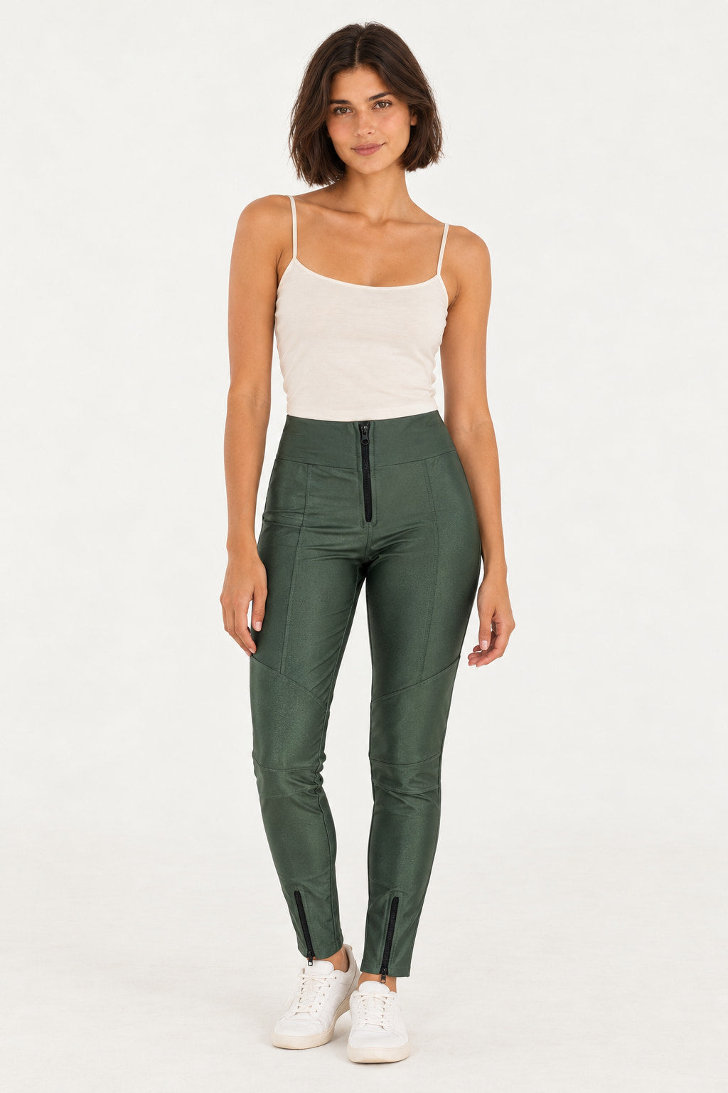 Verde | Calça skinny recortes Mali Vintedoisk verde com zíper na frente e nos tornozelos, vestida em modelo com regata branca