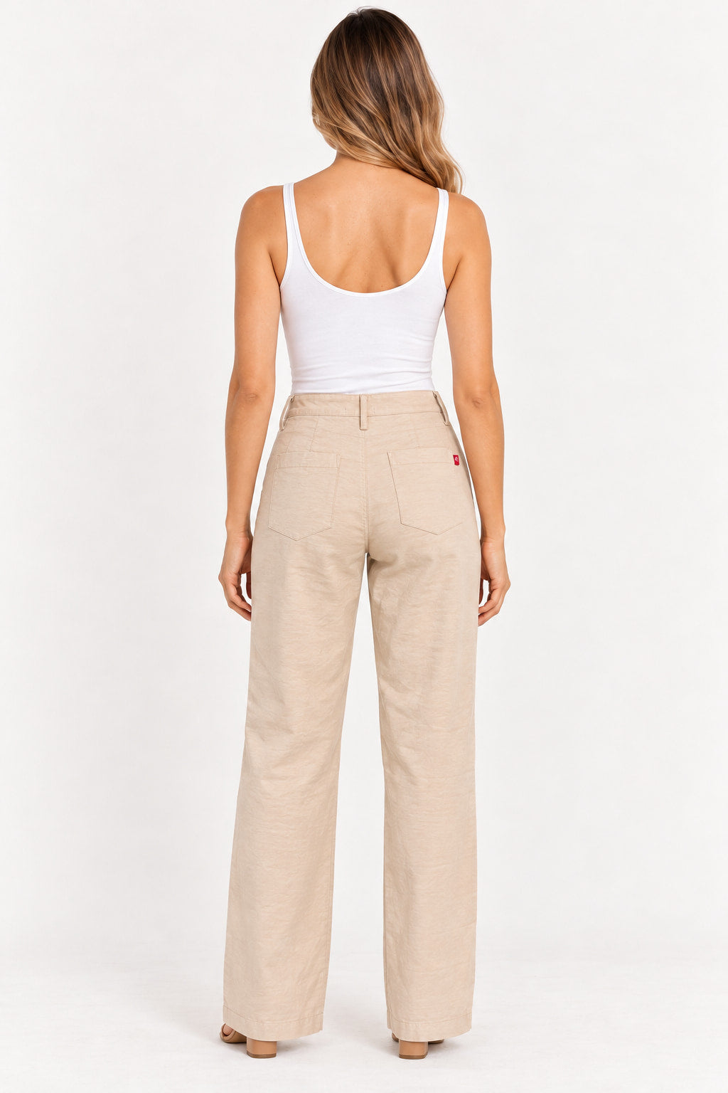 Bege | Calça Wide Leg Revanche bege vista de costas, com bolsos traseiros e modelo de regata branca