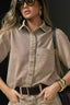 Camisa Alcance Essential caqui de manga curta, com bolso no peito, usada por modelo com óculos escuros e cinto marrom