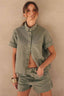 Camisa Essential Alcance verde com manga curta e bolso no peito, vestida na modelo com short jeans da mesma cor