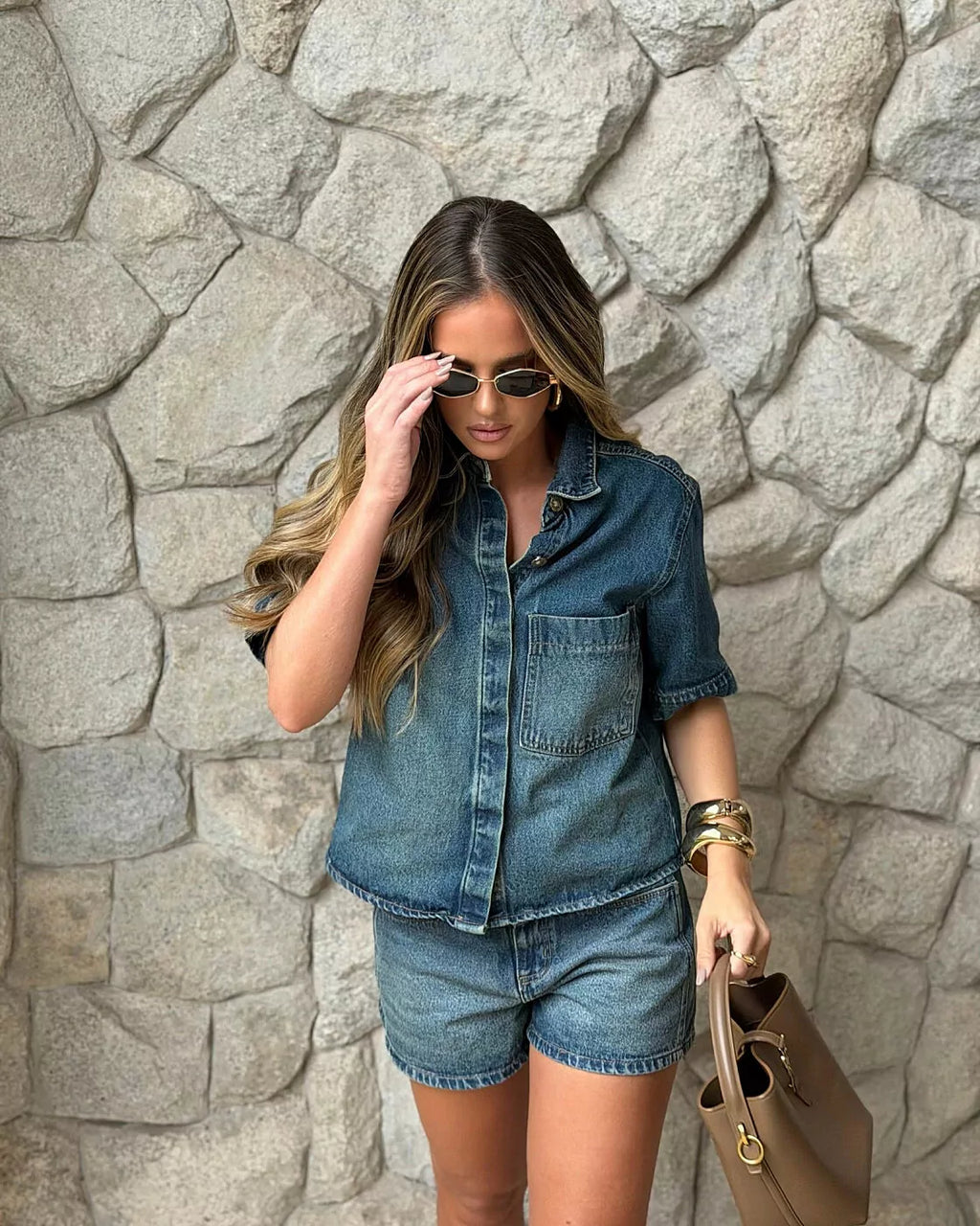 Camisa Jeans Essential Alcance em jeans com short jeans combinando e bolsa caramelo na mão