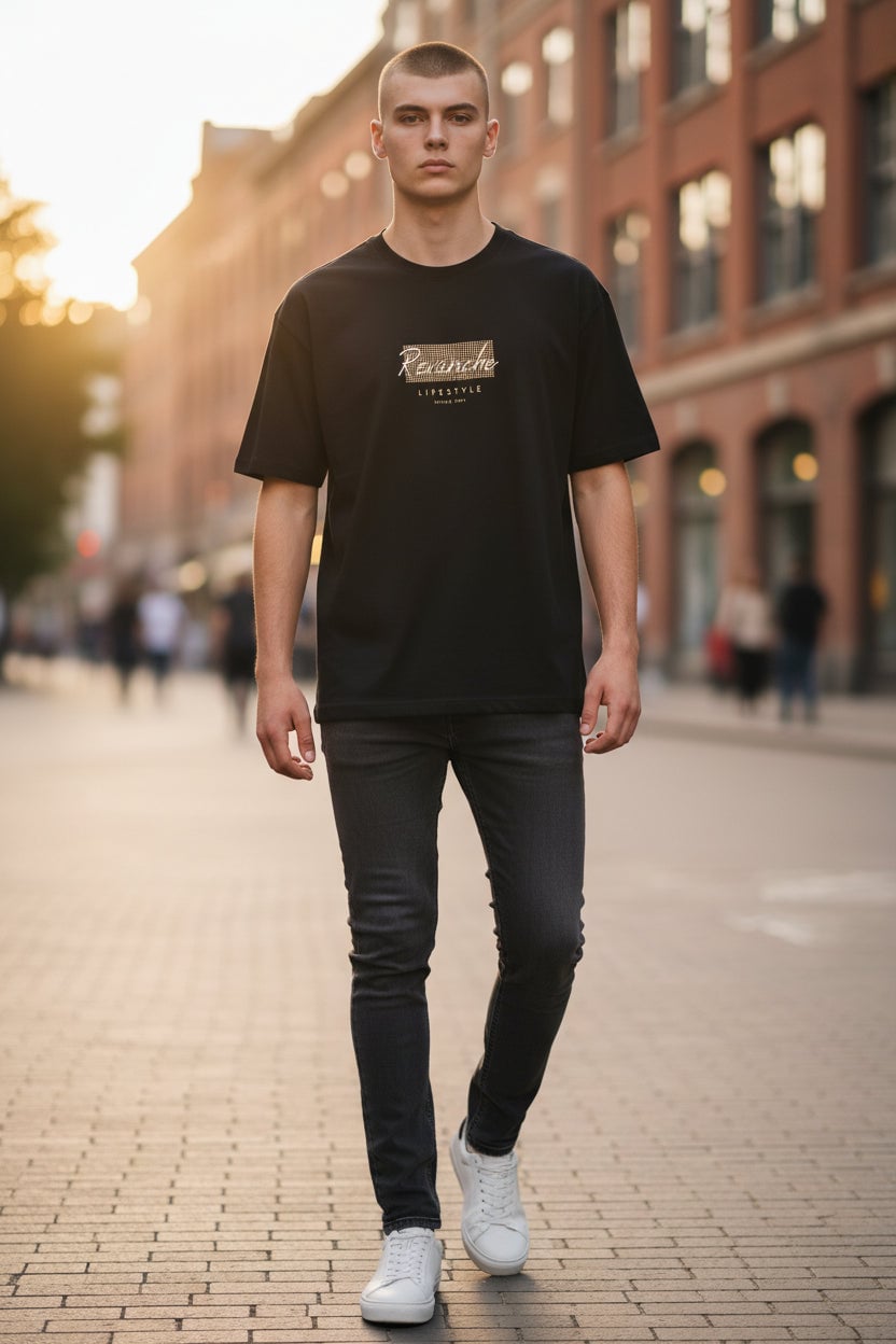 Camiseta bordada Revanche masculina manga curta preta com jeans escuro e tênis branco em rua ao entardecer