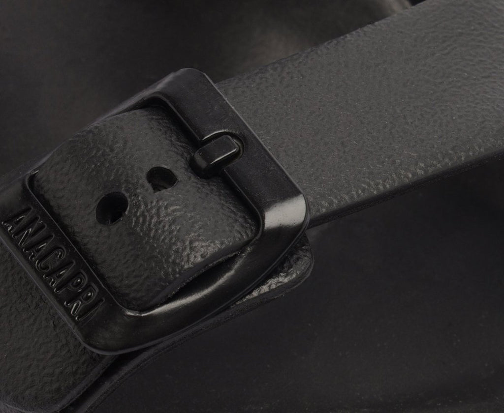 Detalhe da fivela do chinelo Anacapri preto com a marca em relevo na tira
