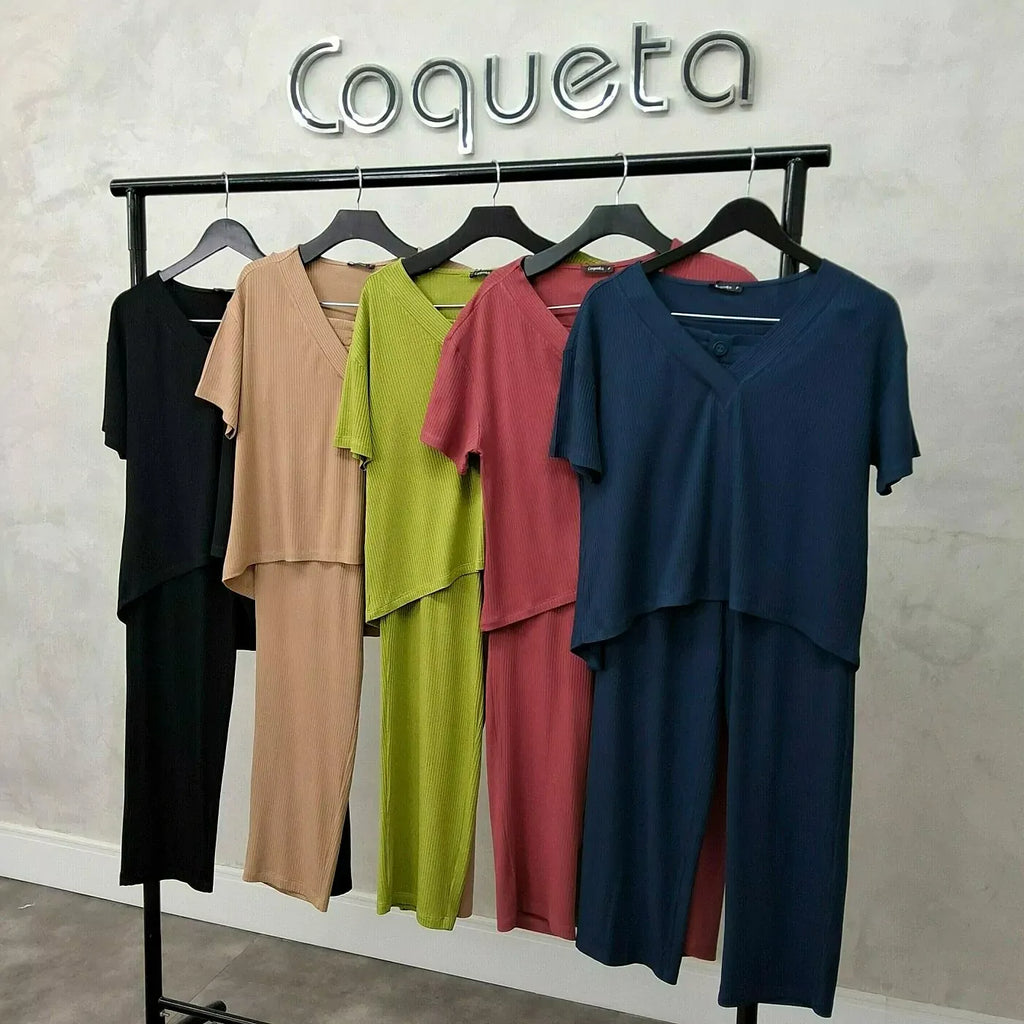 Conjuntos Calça e Blusa Canelado Coqueta em preto, bege, verde, vermelho e azul marinho pendurados em arara preta, com a logo