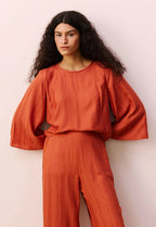 Detalhe do tecido e acabamento da blusa cropped quadradinha Cacay