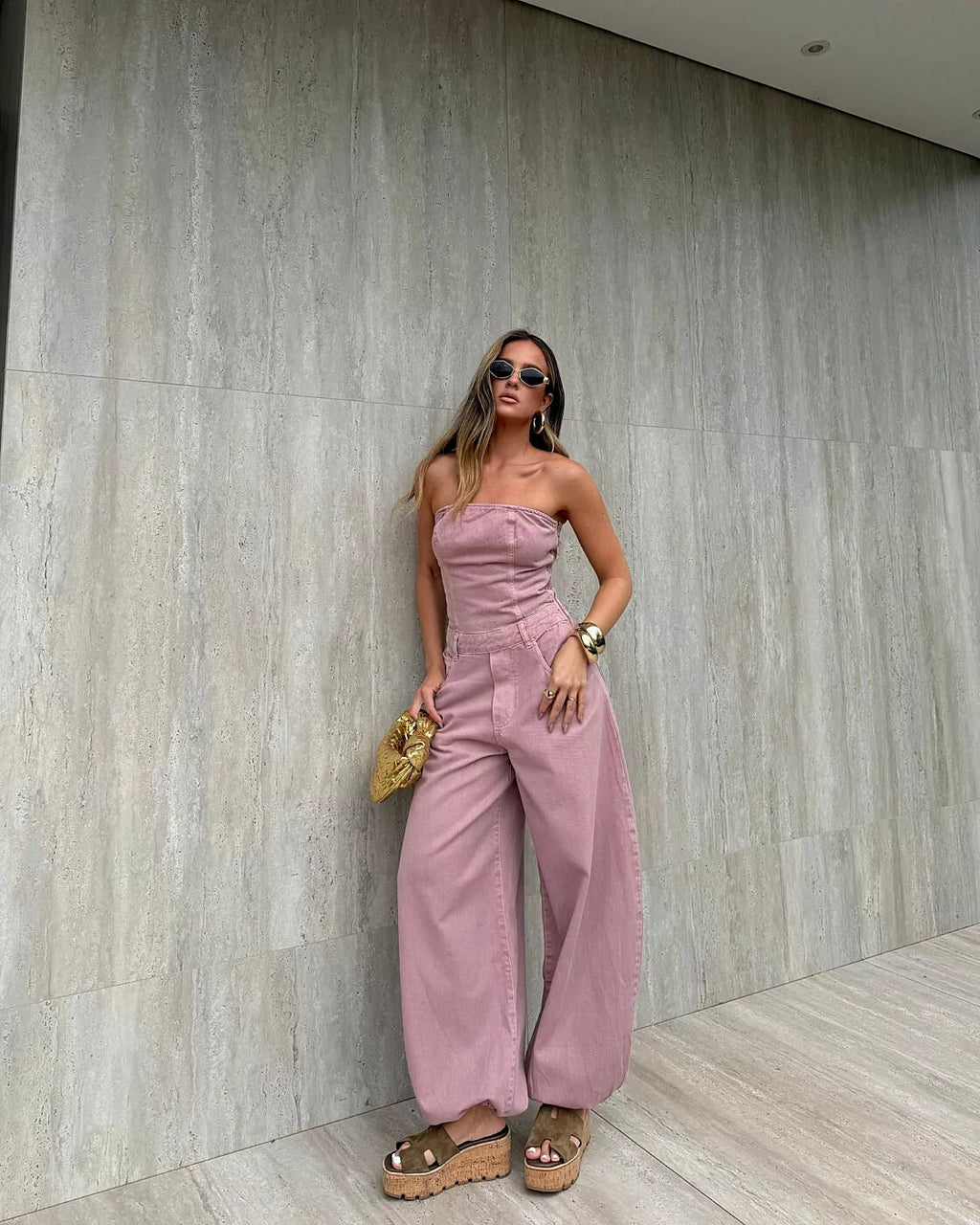 Macacão Aladim Cloud Alcance rosé de tomara que caia e calça ampla com barra franzida, modelo de óculos escuros posando de fr