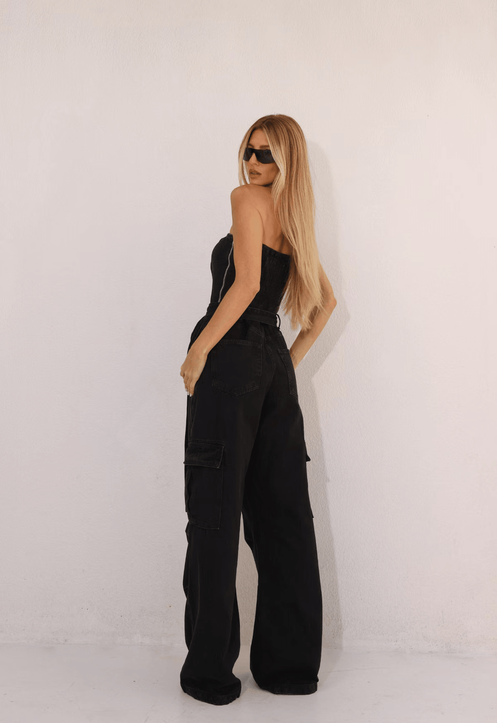 Macacão Alcance Miami Utility preto visto de costas, com bolsos cargo laterais na calça larga