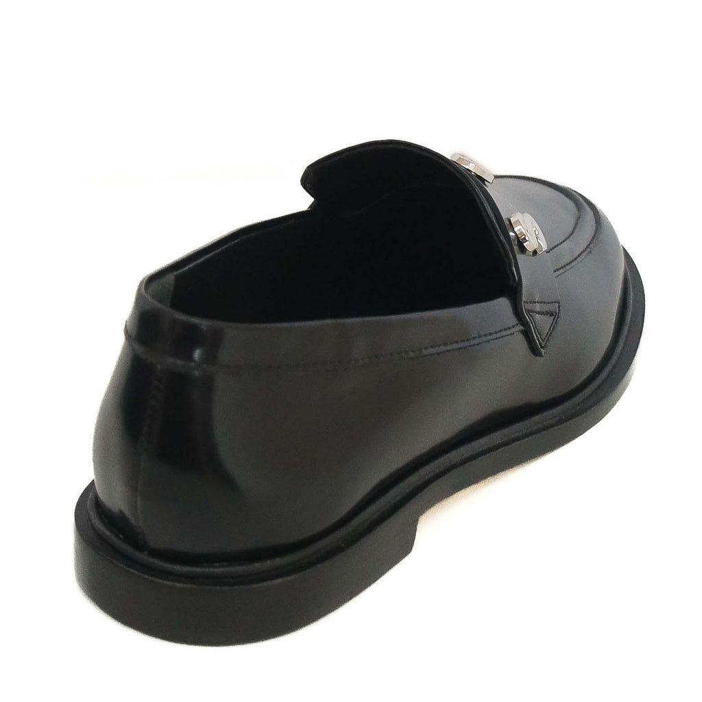 Mocassim Schutz couro logo prata na cor preto, vista traseira em diagonal mostrando o calcanhar e o salto