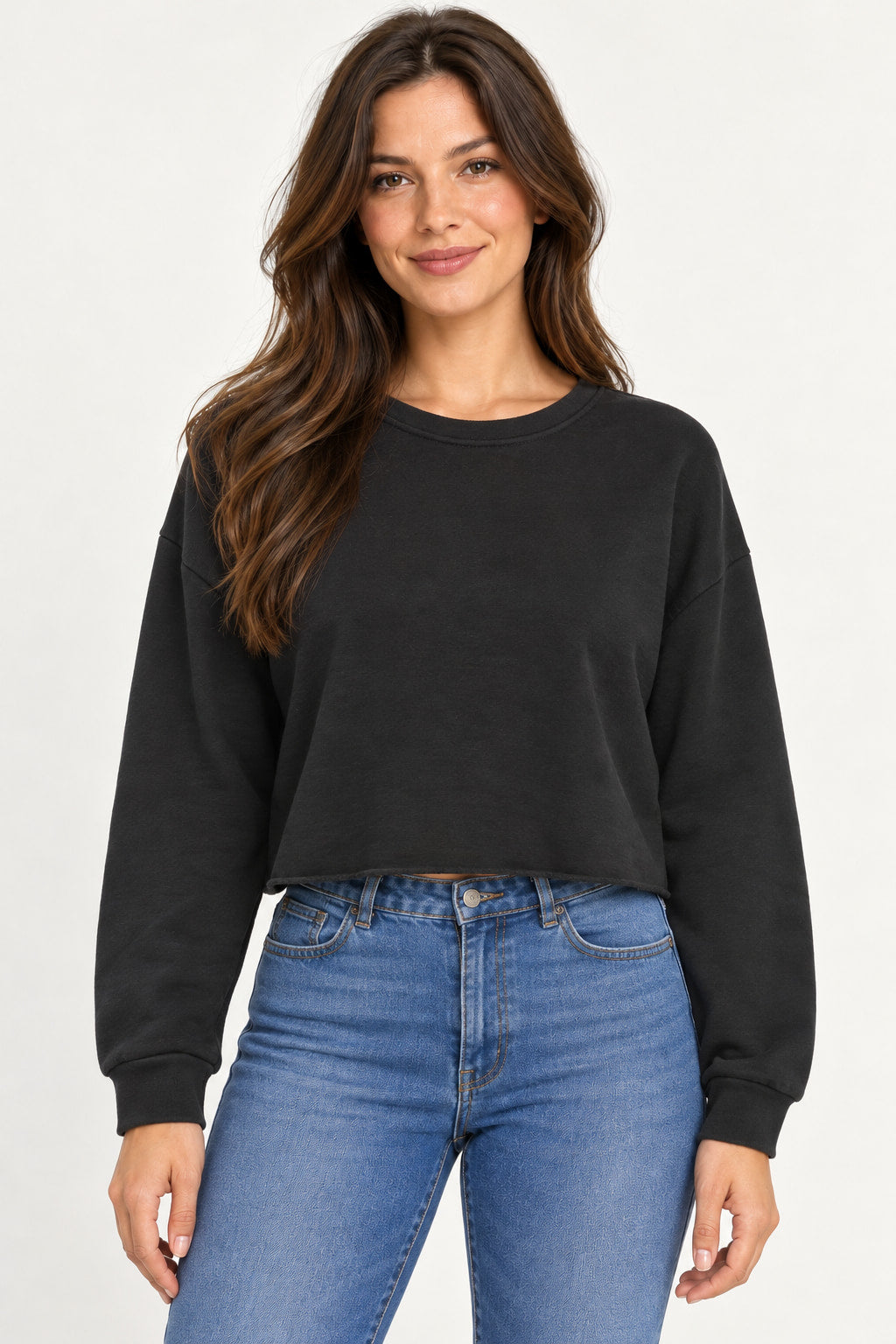 Preto | Blusa Moletom Cropped Alcance preta, de manga longa e gola redonda, vestida em modelo de cabelos castanhos com jeans azul