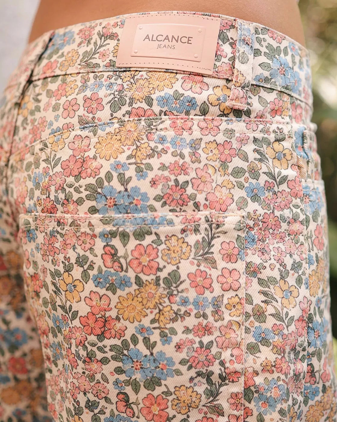 Detalhe do bolso traseiro do short Alcance Vintage Bloom estampado, com etiqueta de couro da marca