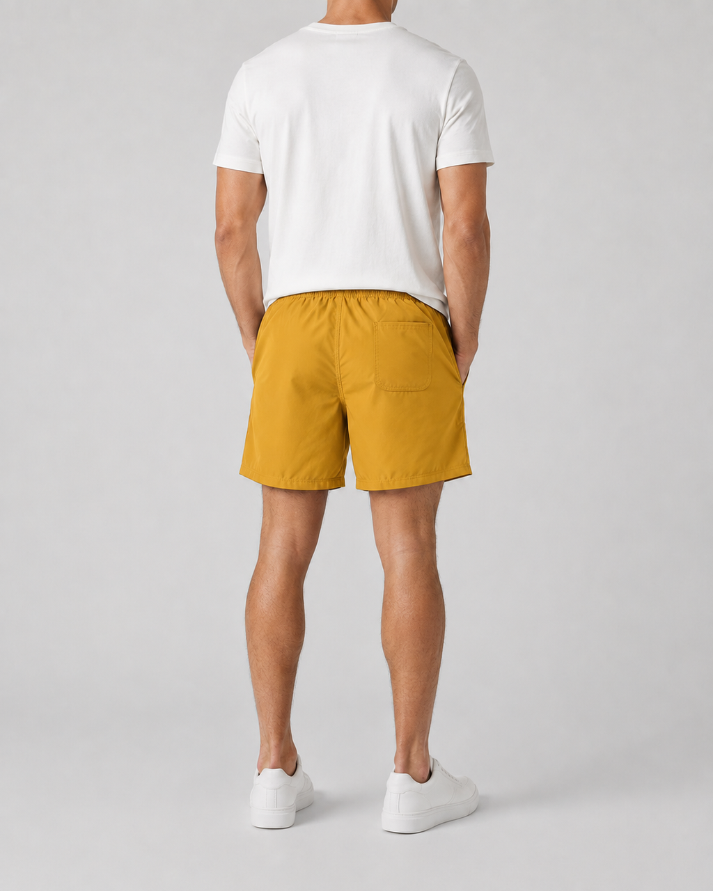 Shorts masculino Gajang liso mostarda visto de costas, com cós elástico e bolso traseiro, com camiseta branca