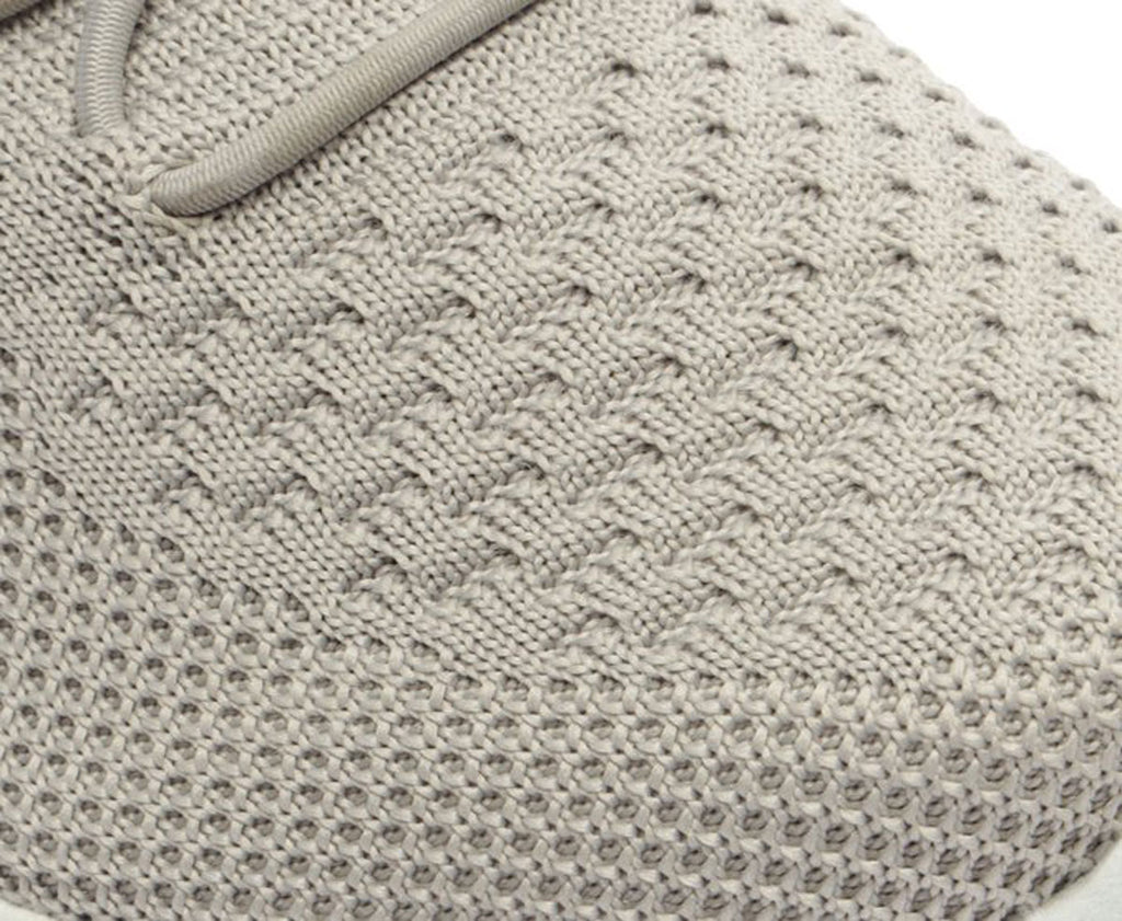 Detalhe da textura da malha em relevo do Tênis Sporty Knit Anacapri cinza, próximo à biqueira