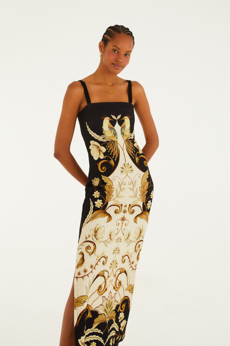 Vestido Midi Milena Farm Rio estampado em preto e dourado, com alças finas, vestido na modelo com fenda lateral Imagem principal do produto